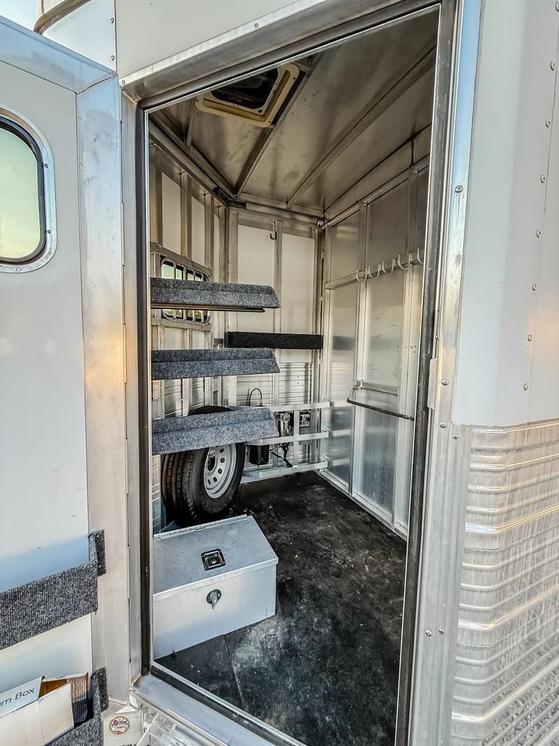 Open dressing room door showing saddle racks and hooks